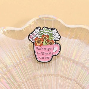 Detailed shot of pink flower cup enamel pin with Don't forget to fill your own cup text