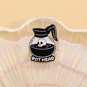 Detail of enamel pin featuring a skull in a coffee pot with POT HEAD text
