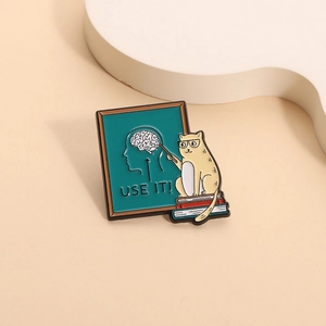 Emaille-Pin Katzenlehrer mit Brille und USE IT Gehirn-Slogan auf der Schultafel