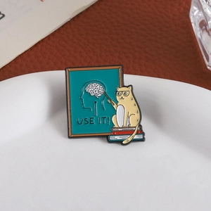 Detail der kreativen Emaille-Anstecknadel Katzenlehrer mit USE IT Gehirn-Slogan