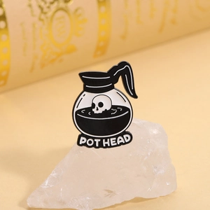 Creative coffee pot enamel pin with skull element and POT HEAD text in black and white
