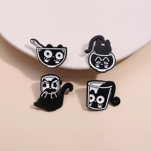 Ensemble de quatre pin's en émail chat noir et blanc sur des supports d'exposition
