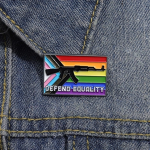 Macro shot of Defend Equality enamel pin with progress pride stripes on denim jacket