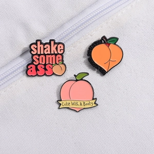 Three-piece peach enamel pins set with humorous slogans on white textured fabric