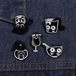Détail de l'ensemble de pins en émail chats noirs mignons sur du tissu en jean bleu