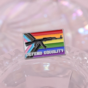 Detail of enamel rainbow badge featuring AK-47 silhouette and Defend Equality text