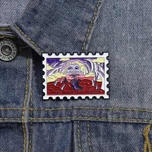 Detail of The Boiling Isles stamp enamel pin displayed on a blue denim jacket lapel