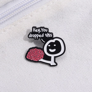 Funny enamel pin featuring a cartoon figure holding a pink brain with a witty speech bubble