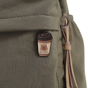 Detail of Capybara enamel pin with Capy-cuinno text on a green canvas backpack