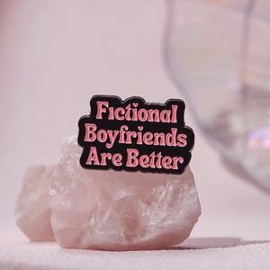 Black enamel pin featuring pink Fictional Boyfriends Are Better text on a pink background