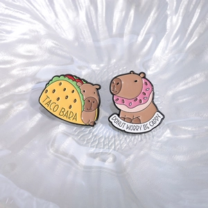 Cute capybara enamel pin set featuring taco and donut designs on white background