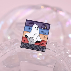 Épingle émaillée fantôme d'Halloween avec un fantôme blanc et texte Booooooty sur fond coloré