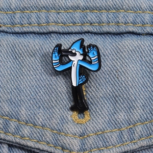 Macro di una spilla smaltata con uccello blu fissata su una giacca di jeans chiara