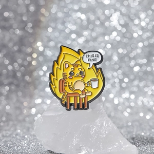 Funny This is Fine meme cat enamel pin sitting with coffee cup on a crystal base
