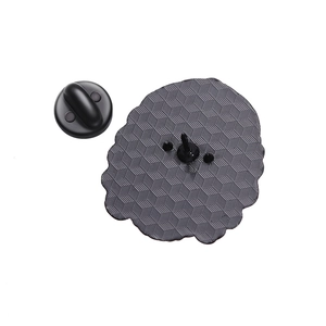 Detail of the honeycomb textured metal back and black rubber clutch for the monster brooch