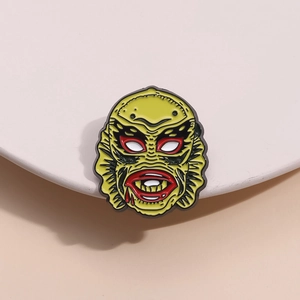 Cartoon monster head enamel pin in green and red finish with creative fish design