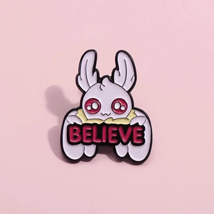 Mini pink bat enamel pin with red eyes holding a Believe sign on a pink background