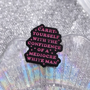 Black enamel brooch with pink motivational lettering on an iridescent shell background