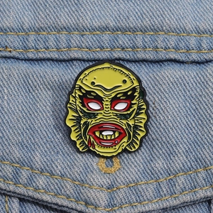Green Creature from the Black Lagoon enamel pin pinned on blue denim jacket pocket