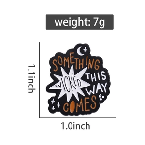 Detailed view of enamel pin with 'Something Wicked This Way Comes' text and 7g weight tag