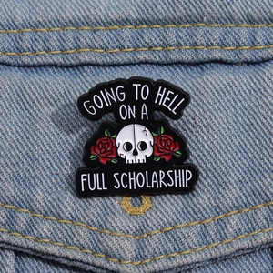 Skull and red roses enamel brooch with quote pinned on blue denim jacket