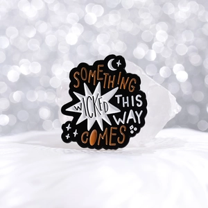 Artistic gothic enamel pin with Something Wicked This Way Comes text and celestial moon