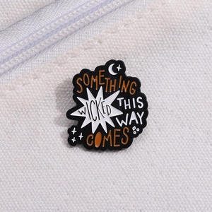 Detail of Something Wicked This Way Comes enamel pin on a white canvas bag