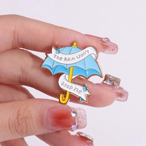 Emaille-Brosche in Regenschirmform mit dem motivierenden Spruch 'The Rain Won't Stop Me'