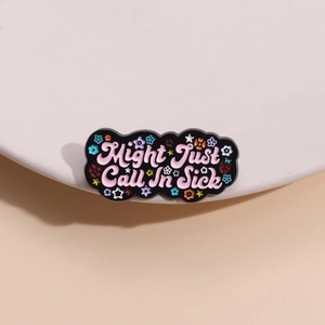 Whimsical enamel brooch with Might Just Call In Sick text and pink floral patterns