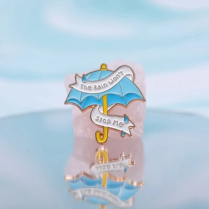 Blauer Emaille-Pin Regenschirm mit Spruch The Rain Won't Stop Me auf blauem Hintergrund