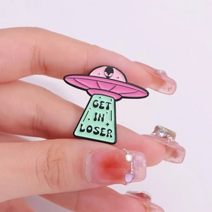 Punk style UFO enamel pin featuring a pink spaceship and Get In Loser slogan