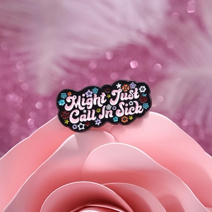 Black enamel pin with Might Just Call In Sick text and colorful floral accents