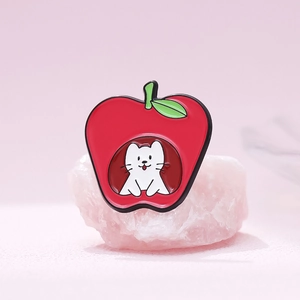 Enamel pin featuring a cute white cat inside a red apple on a pink background