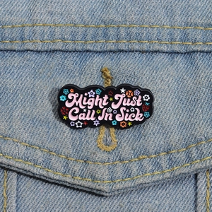 Close-up of Might Just Call In Sick enamel pin on blue denim jacket pocket texture