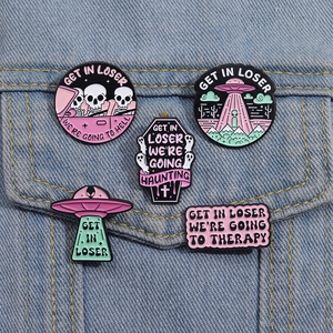 Five-piece cartoon alien and skull enamel pins set on blue denim jacket pocket