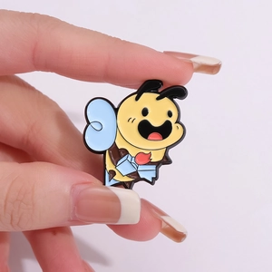 Cute cartoon honey bee enamel brooch pin held in hand to show small jewelry size