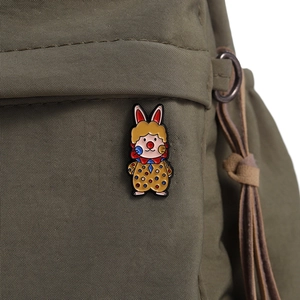 Close-up of a cartoon bunny enamel brooch in circus outfit pinned on a canvas backpack