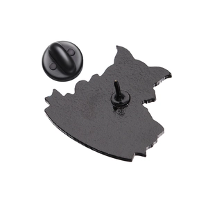 Detailed back view of enamel pin with rubber clutch on a textured black alloy surface