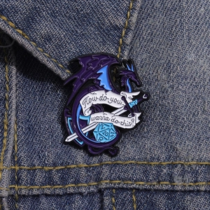 Detail of blue dragon enamel pin with D20 dice on a dark blue denim jacket texture