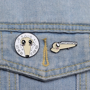 Detailed view of two cartoon long-nose dog enamel pins pinned on a denim jacket surface