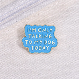 Blue enamel dog lover pin with gold trim and funny phrase on white canvas background