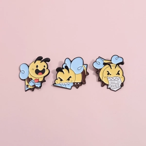 Three-piece set of cute cartoon bee enamel pins in yellow and blue on pink background