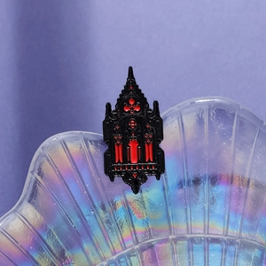 Gothic cathedral brooch in black and red enamel finish on a shell tray