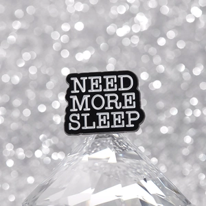 Minimalist alloy enamel pin badge featuring NEED MORE SLEEP quote on a crystal stand