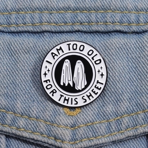 Nahaufnahme einer lustigen Geister-Emaille-Anstecknadel auf einer Denim-Jacke mit Text