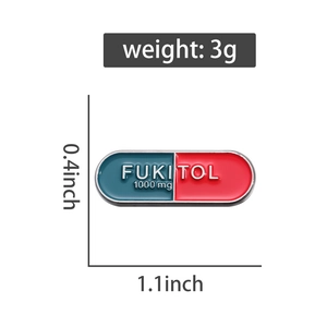 Detail view of colorful capsule brooch with FUKITOL lettering and dimensions 0.4x1.1 inch