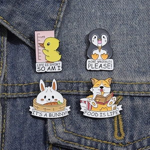 Gros plan de quatre pins en émail colorés avec animaux sur une veste en denim
