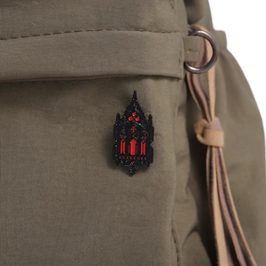 Gothic castle cathedral brooch detail with black alloy and red enamel on olive canvas