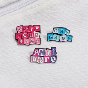 Three enamel pins set with Slogan Not Your Baby, Cry Baby and Anti Hero on white canvas