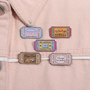 Macro shot of 5 stamp-shaped enamel pins with humorous lifestyle texts on pink denim
